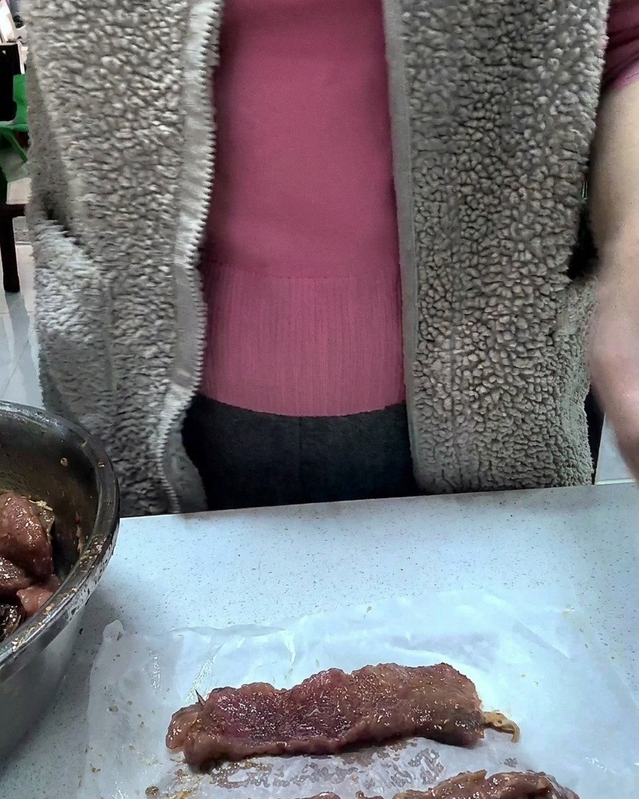 Porzioni individuali di maiale marinato avvolte ordinatamente nella pellicola trasparente su un bancone da cucina.