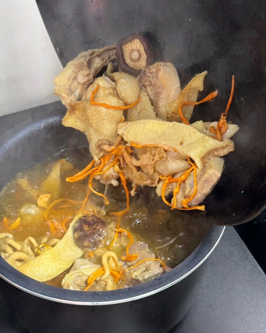 Brodo di pollo e funghi trasferito nella pentola di una cuociriso elettrica.