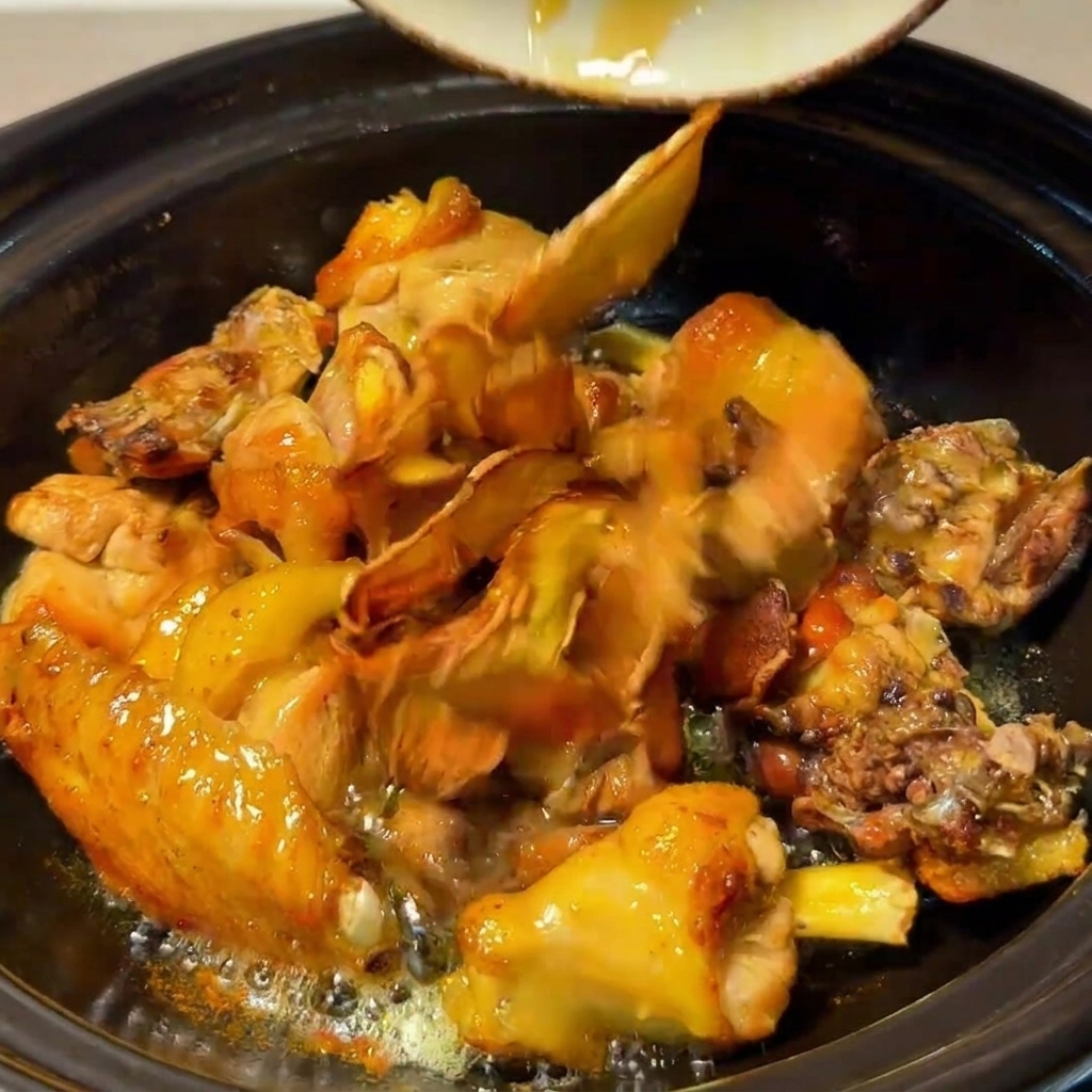 Pollo, funghi, zenzero fritto e giuggiole che cuociono insieme nel tegame.