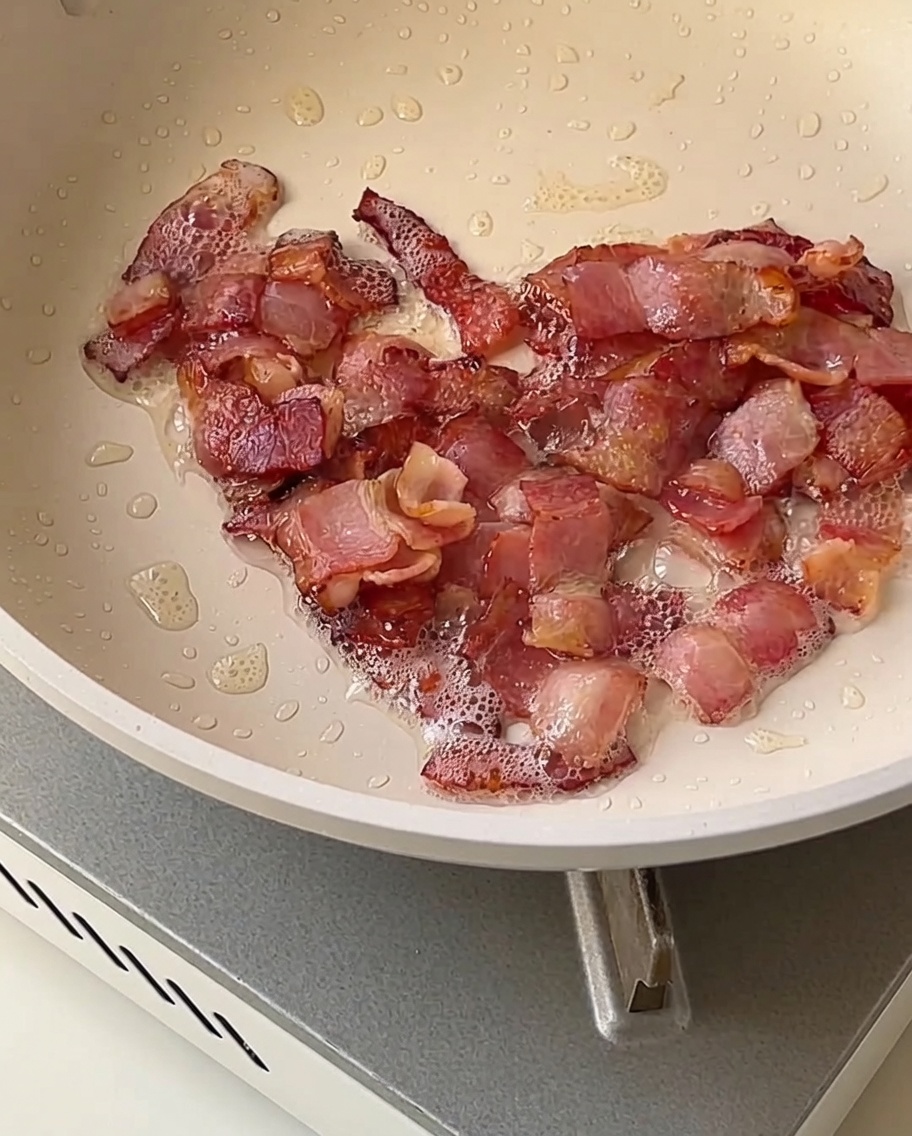 Cubetti di cipolla, sedano e patata rosolati in padella con pezzetti di pancetta croccante dorata.