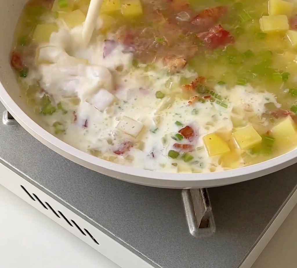 Una base cremosa per clam chowder mescolata con latte, panna e polpa di vongole in padella.