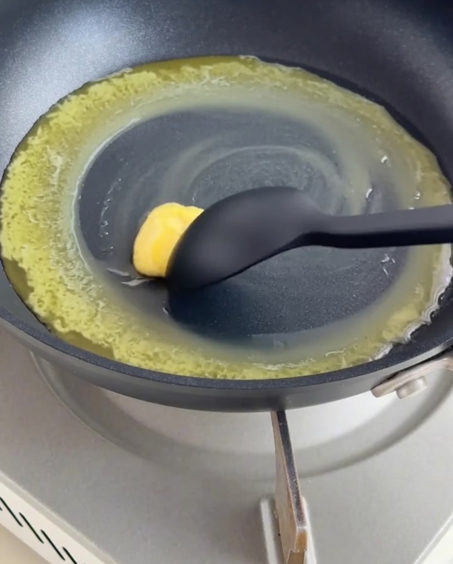 Burro sciolto e farina mescolati insieme in una padella antiaderente scura per formare un roux.