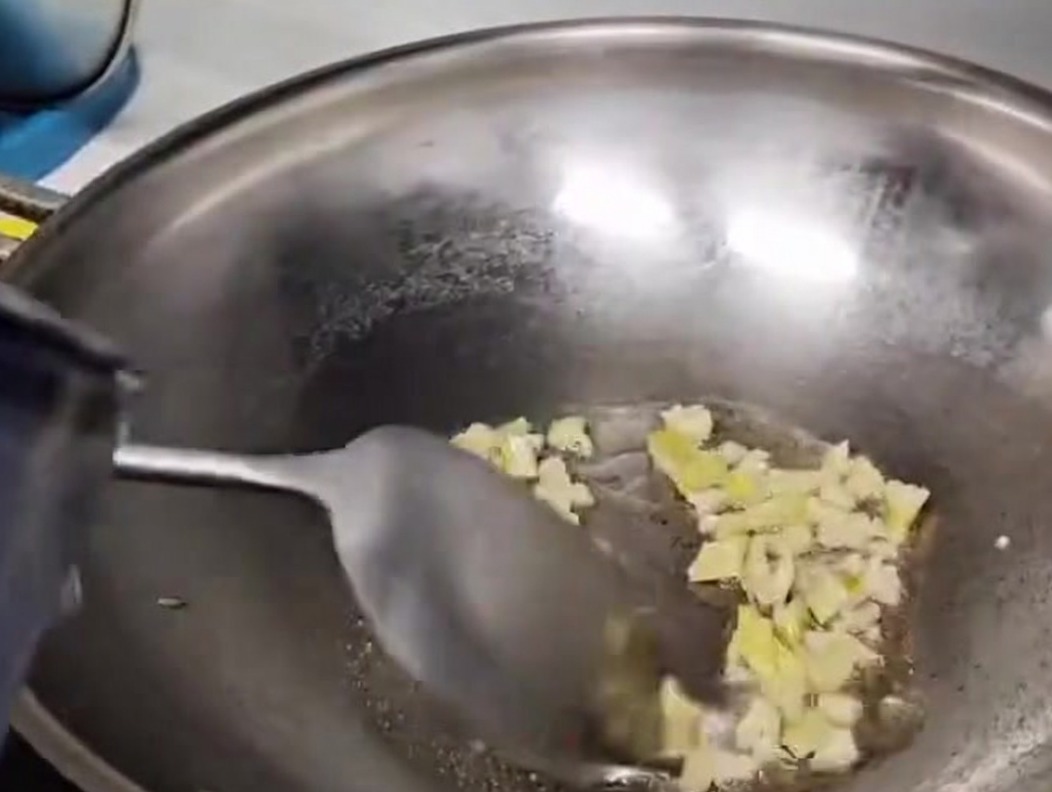 Acqua versata nel wok per formare la base della zuppa.