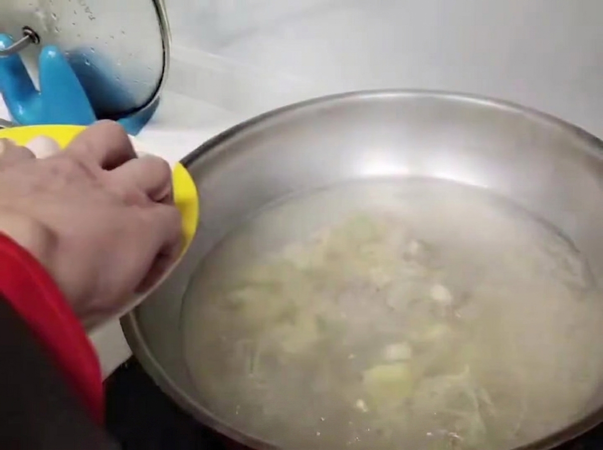 Polpette aggiunte delicatamente nellacqua bollente nel wok.