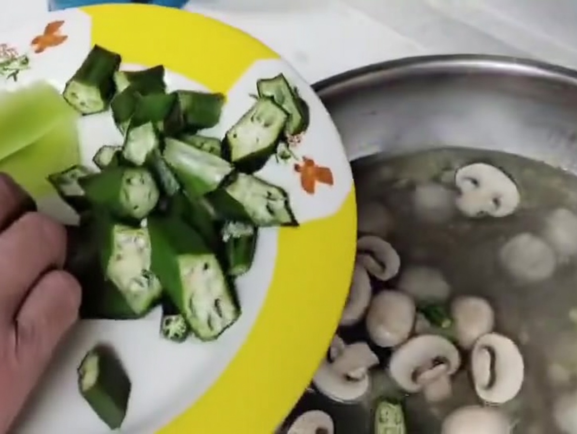 Funghi e okra aggiunti alla zuppa bollente con le polpette.