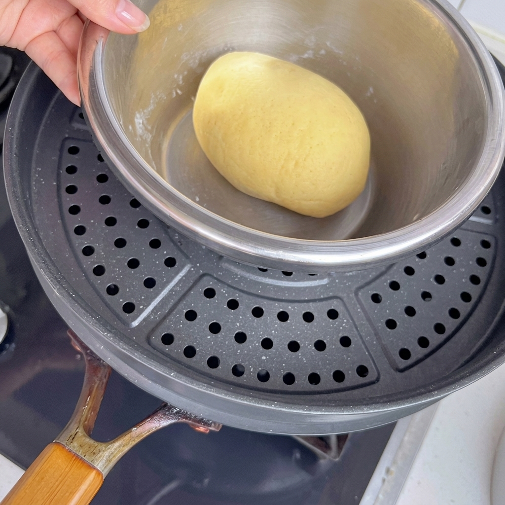 Ciotola con impasto in una pentola con acqua calda.