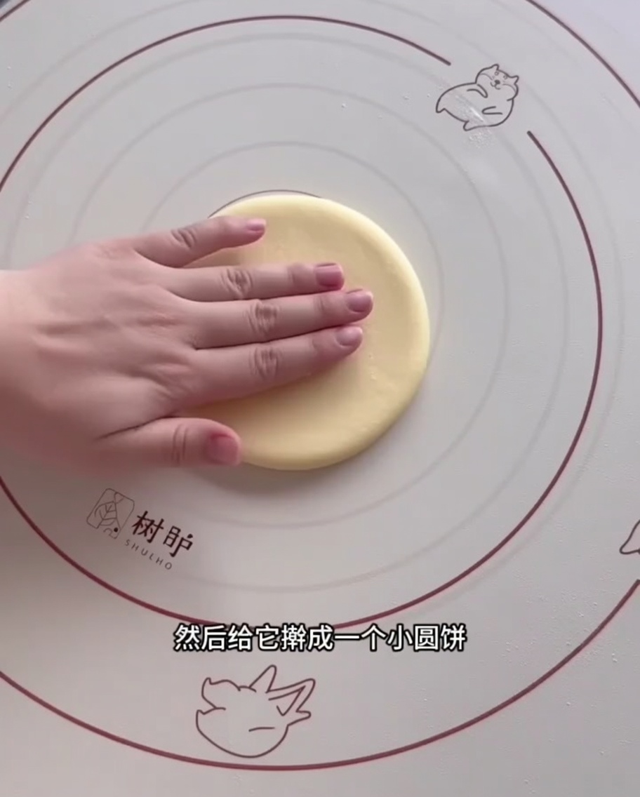 Impasto steso in cerchio con un mattarello su tappetino in silicone.