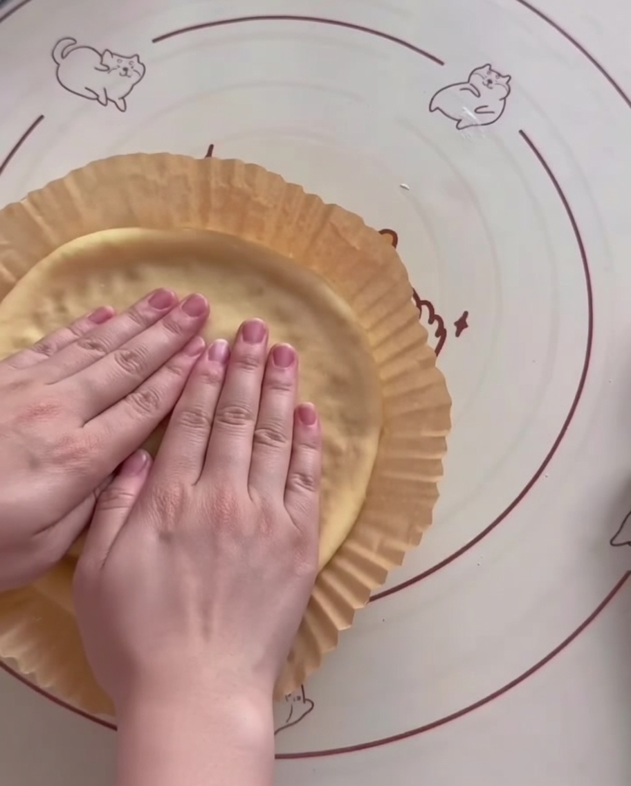Impasto modellato in una teglia per friggitrice ad aria con bordi rialzati.