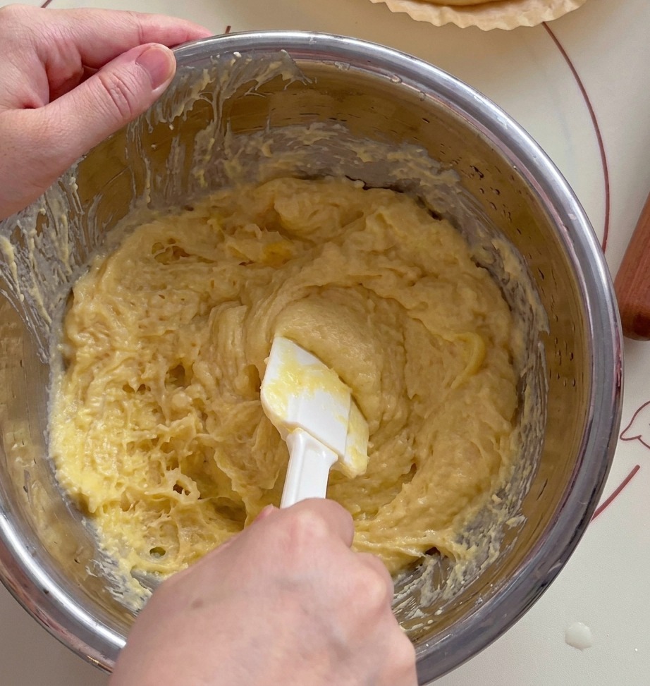 Spatola che schiaccia la polpa di durian in una ciotola.
