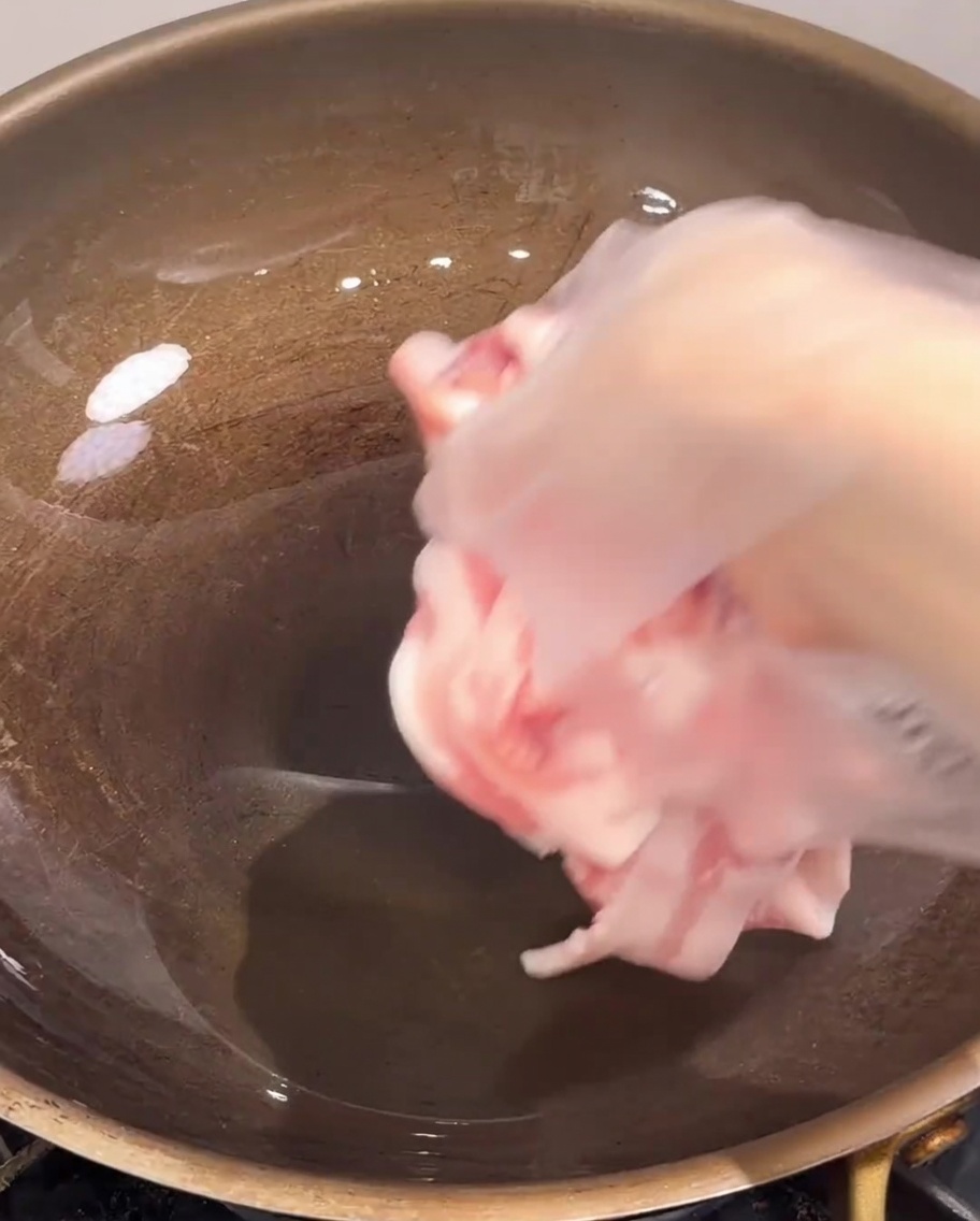 Fette sottili di pancetta cruda messe in una padella calda e vuota.