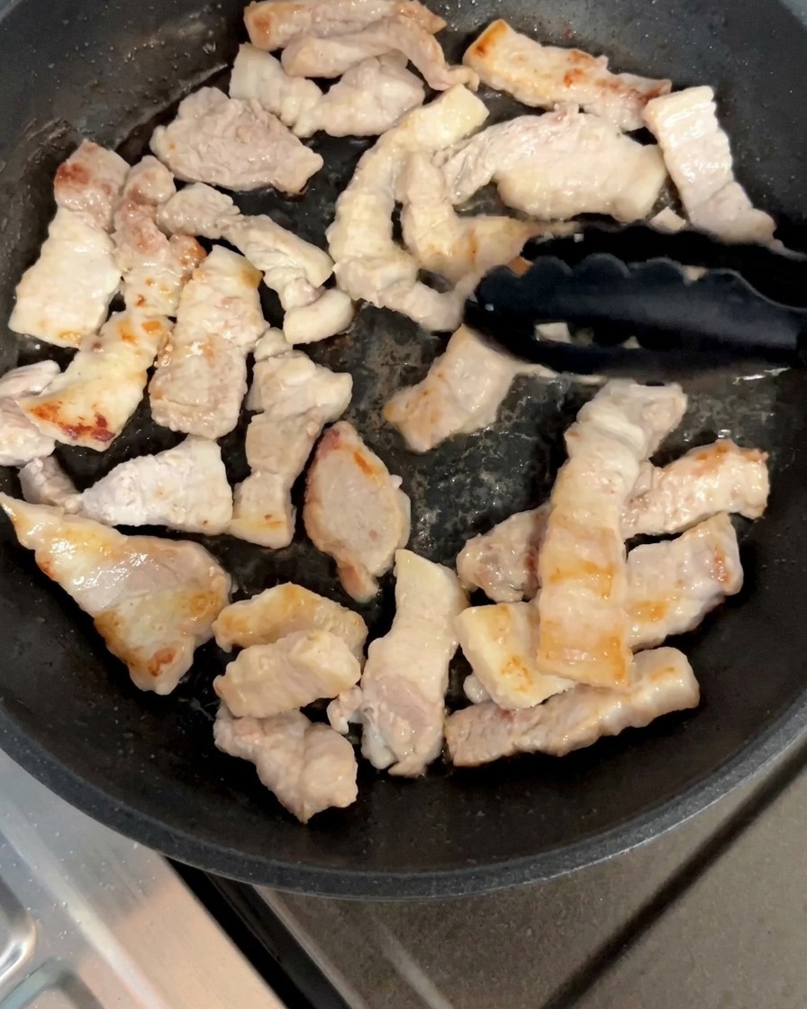 Pezzi di pancetta girati nella padella fino a doratura.