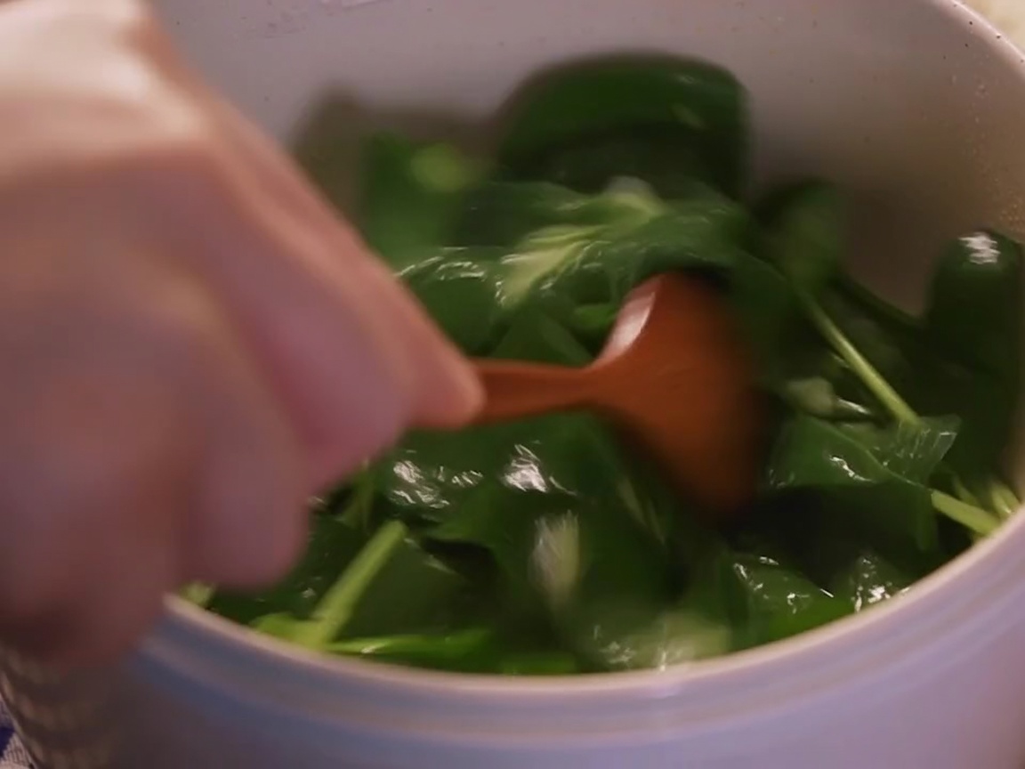Foglie di spinaci freschi saltate in padella fino a quando non sono appena appassite.
