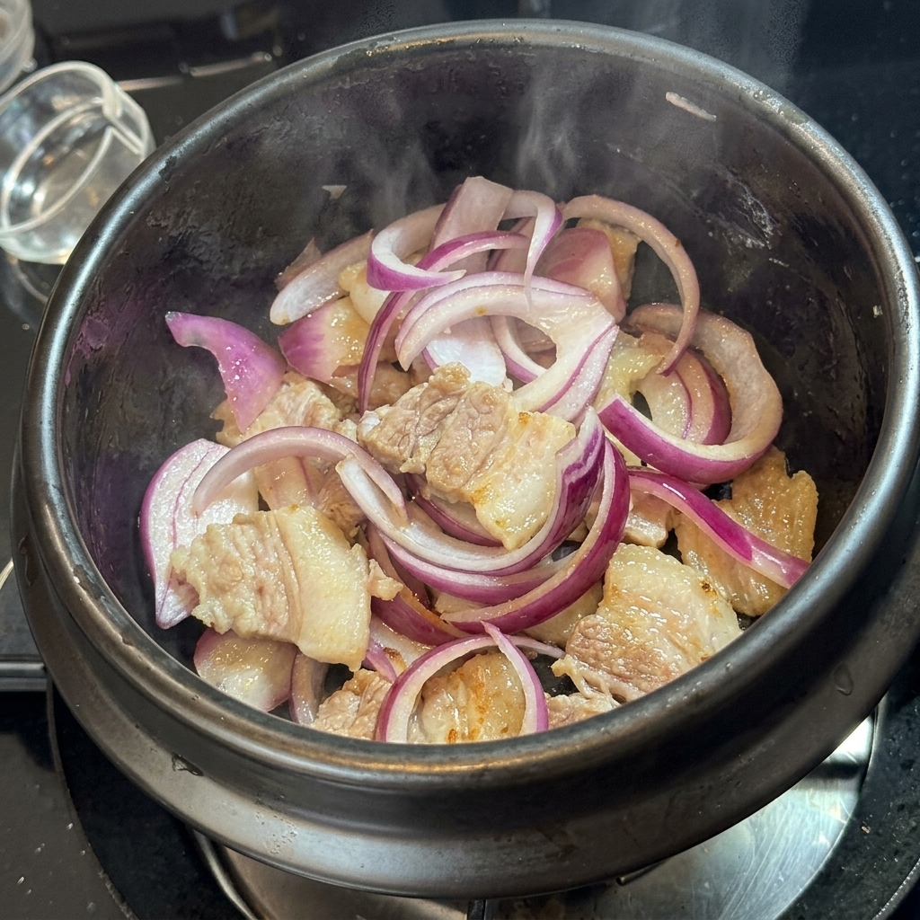 Kimchi mescolato con carne e cipolle nel vaso di pietra.