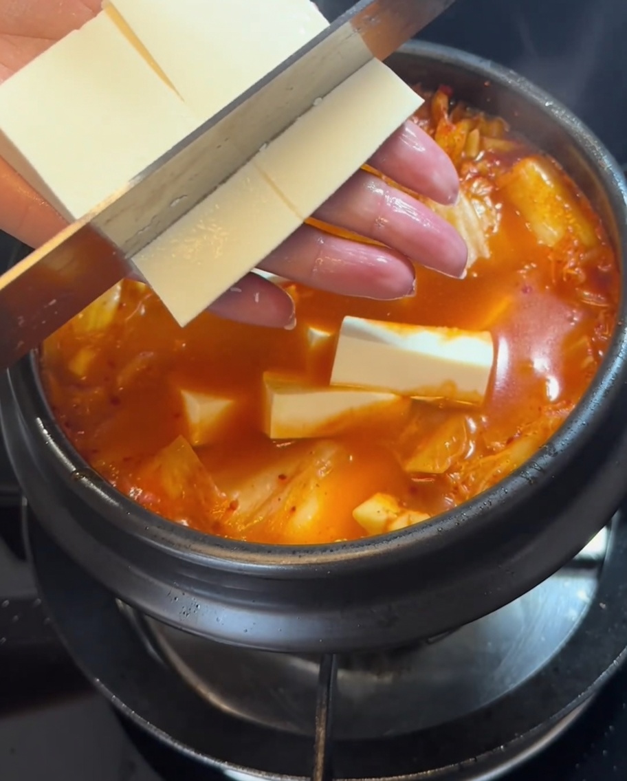 Fette di tofu sodo posizionate delicatamente nello stufato.
