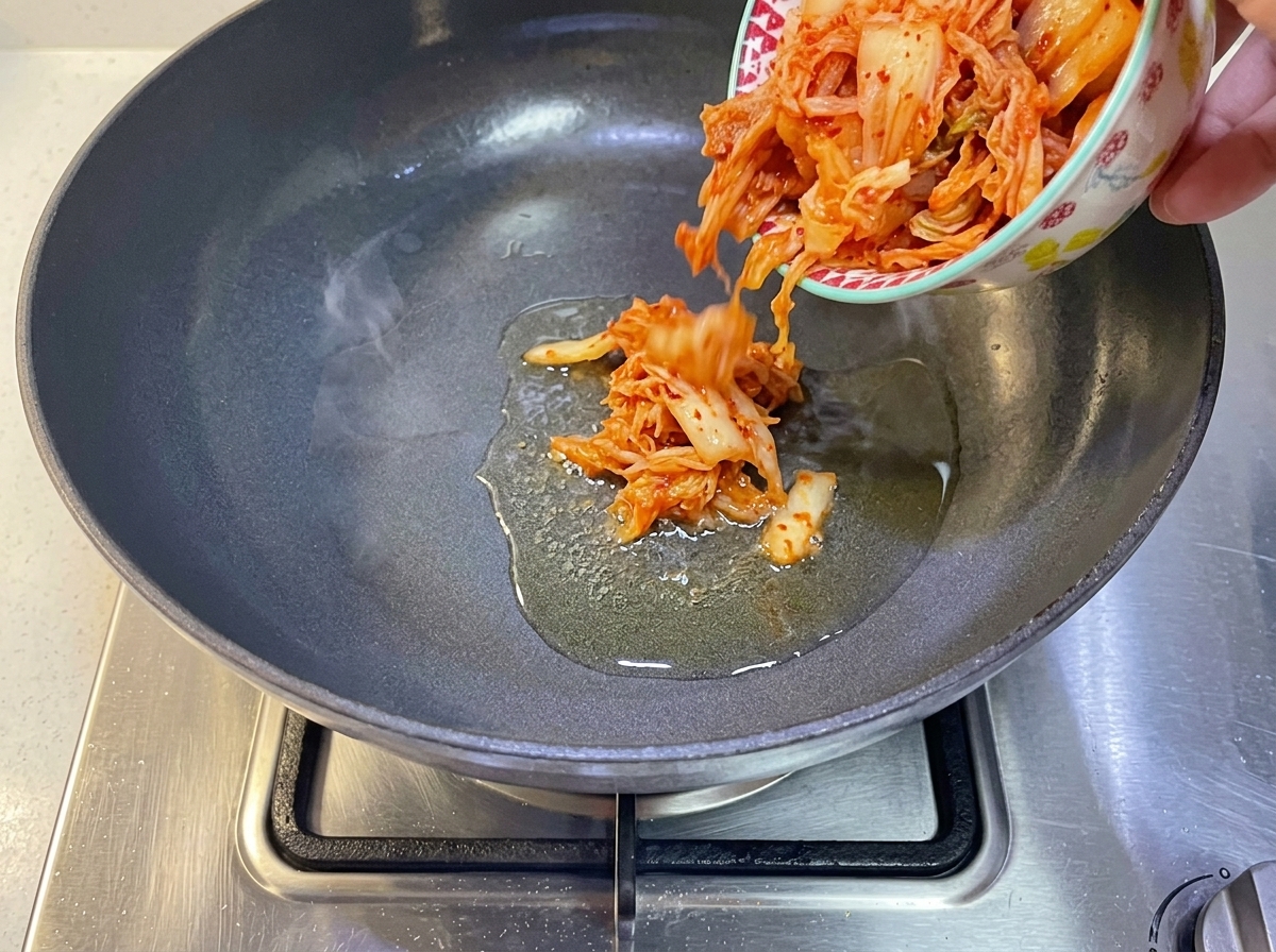 Kimchi coreano versato in una padella con olio caldo.
