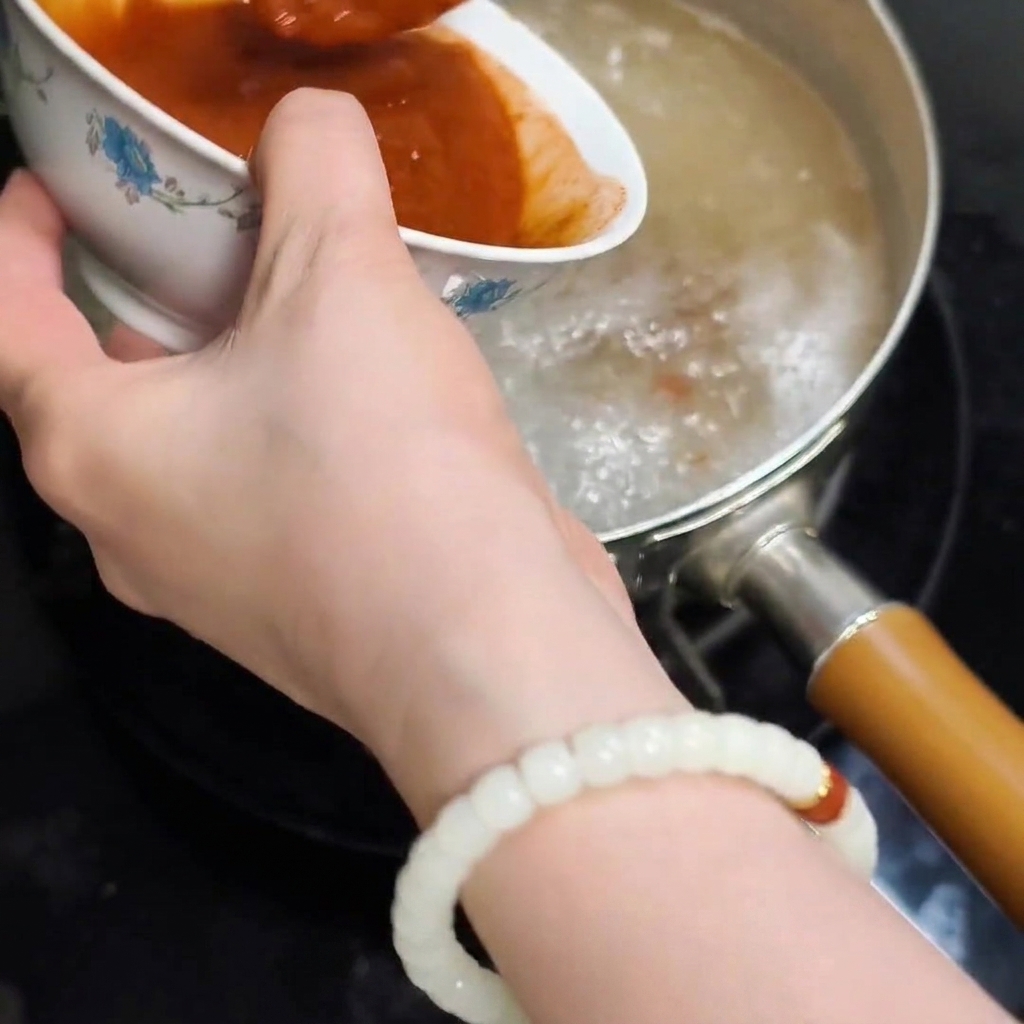 Il composto di paste sciolte versato nellacqua bollente.