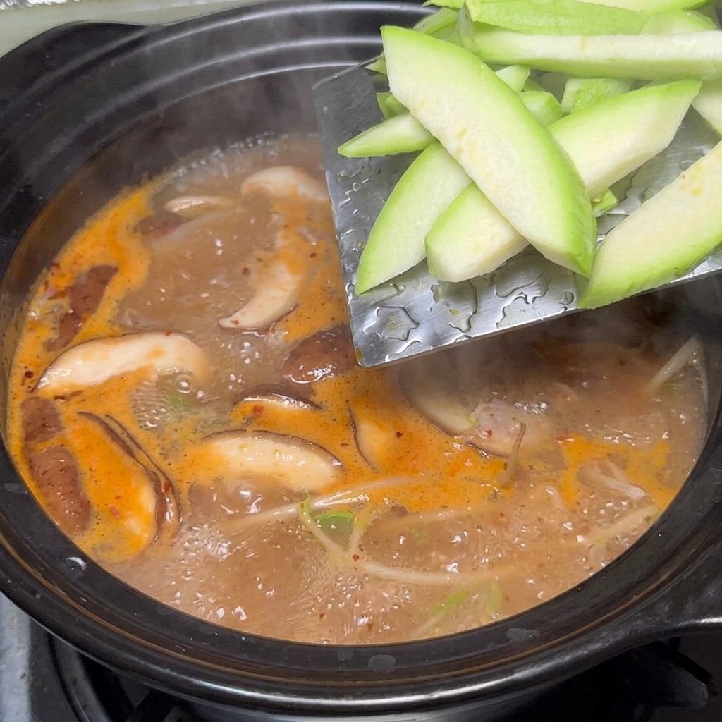 Zucchine aggiunte alla pentola.
