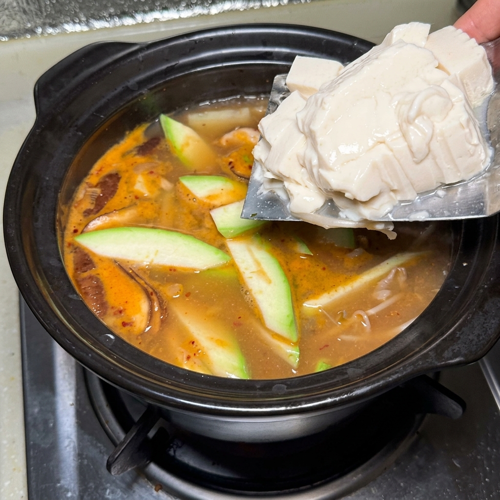 Blocchi di tofu aggiunti delicatamente.