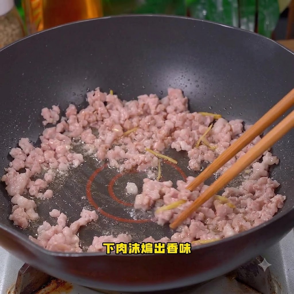 Carne macinata di maiale in cottura mescolata allinterno del wok.