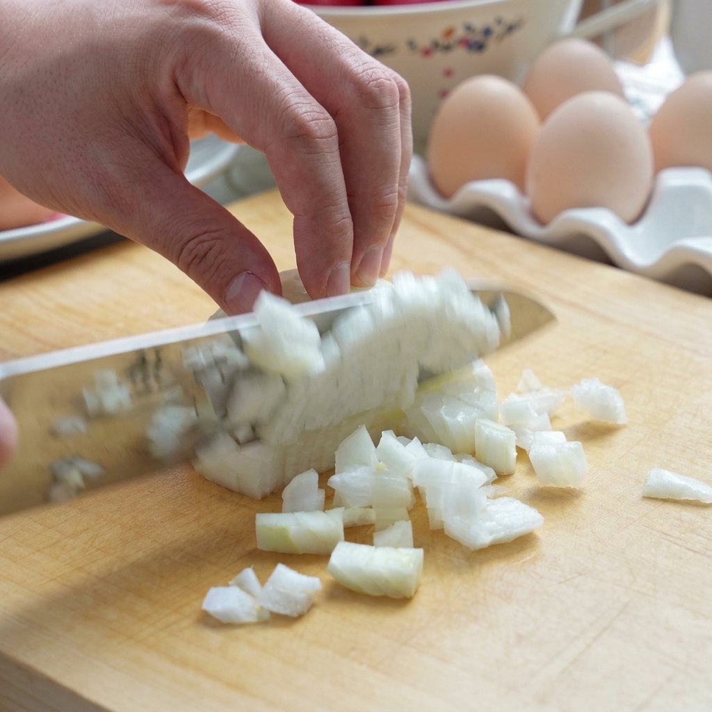 Un pomodoro fresco tagliato a pezzi su un tagliere di legno con un coltello.