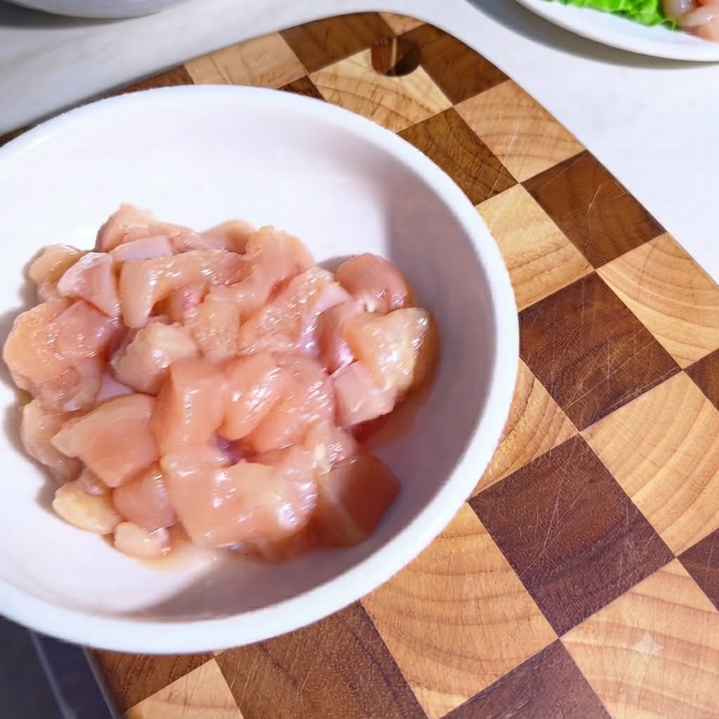 Pezzi di pollo crudo in una ciotola bianca ricoperti di condimenti e olio doliva.