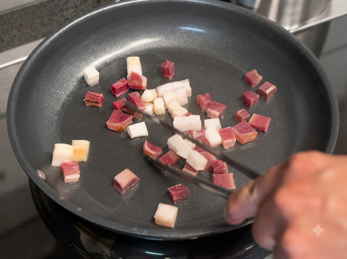 Cubetti di pancetta e carne stagionata che sfrigolano in una padella girati con pinze di metallo.