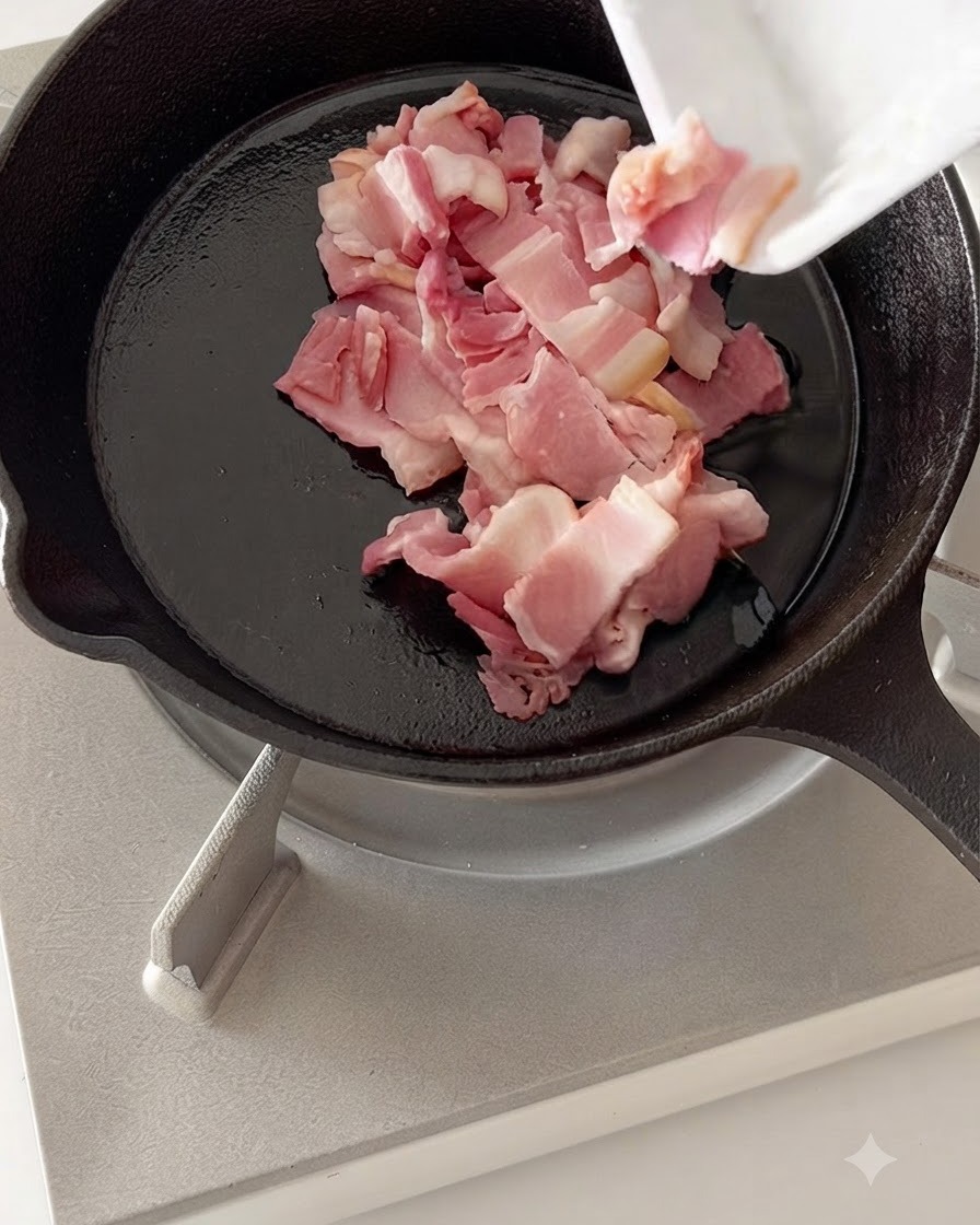 Pezzi di pancetta tagliati che friggono in una padella calda in ghisa.