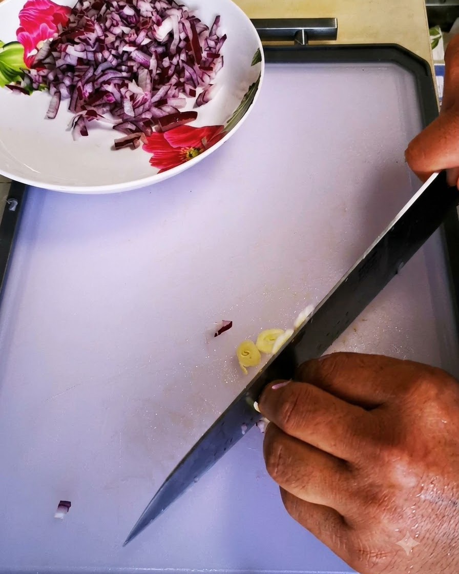 Spicchi daglio tritati finemente con un coltello da chef su un tagliere bianco pulito.