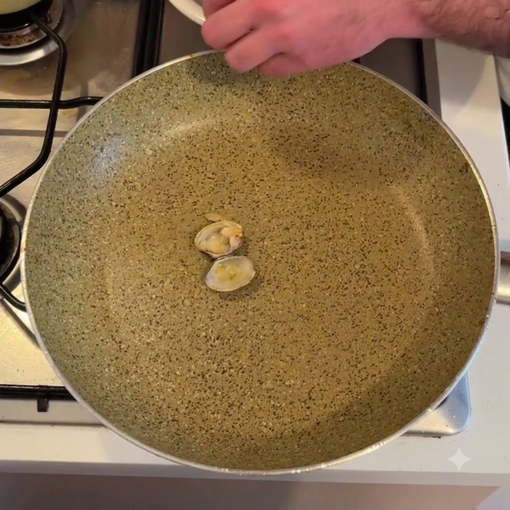 Carne di vongola sgusciata sopra una padella.