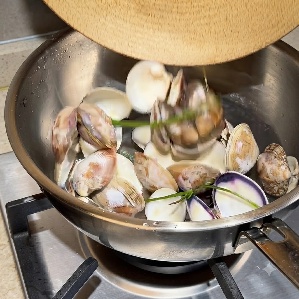 Gusci di vongole vuoti e acqua in ebollizione vigorosa in una pentola di acciaio inossidabile.