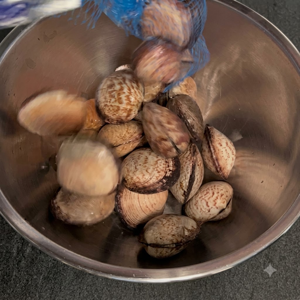 Vongole immerse in una ciotola di metallo con acqua tiepida e sale.