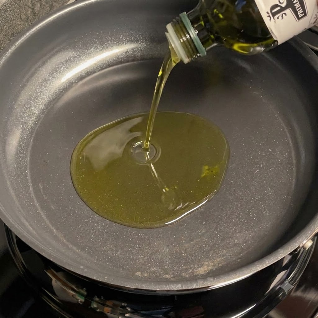 Olio doliva versato in una padella per friggere laglio affettato.