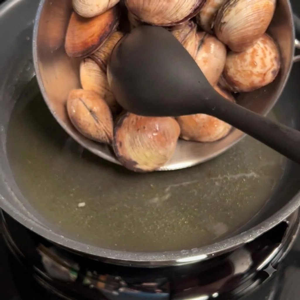Vongole pulite versate dalla ciotola alla padella con lolio allaglio.