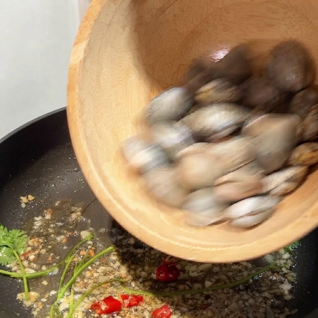 Vongole versate da una ciotola di legno in una padella con aglio e peperoncino soffritti.
