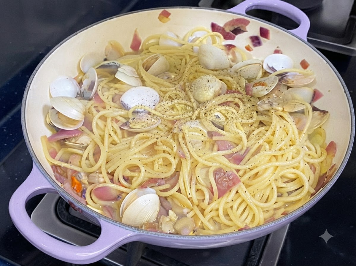 Pepe nero fresco macinato cosparso su una padella di spaghetti cotti e vongole.