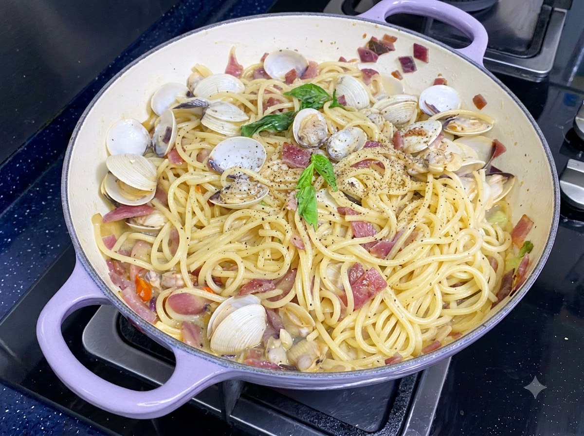Foglie di basilico verde fresco posizionate sopra gli spaghetti alle vongole finiti.