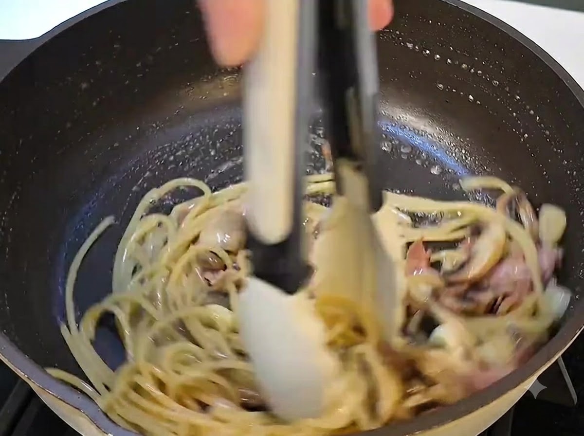 Una vista ravvicinata del burro che viene aggiunto e si scioglie nel composto di pasta nella padella.