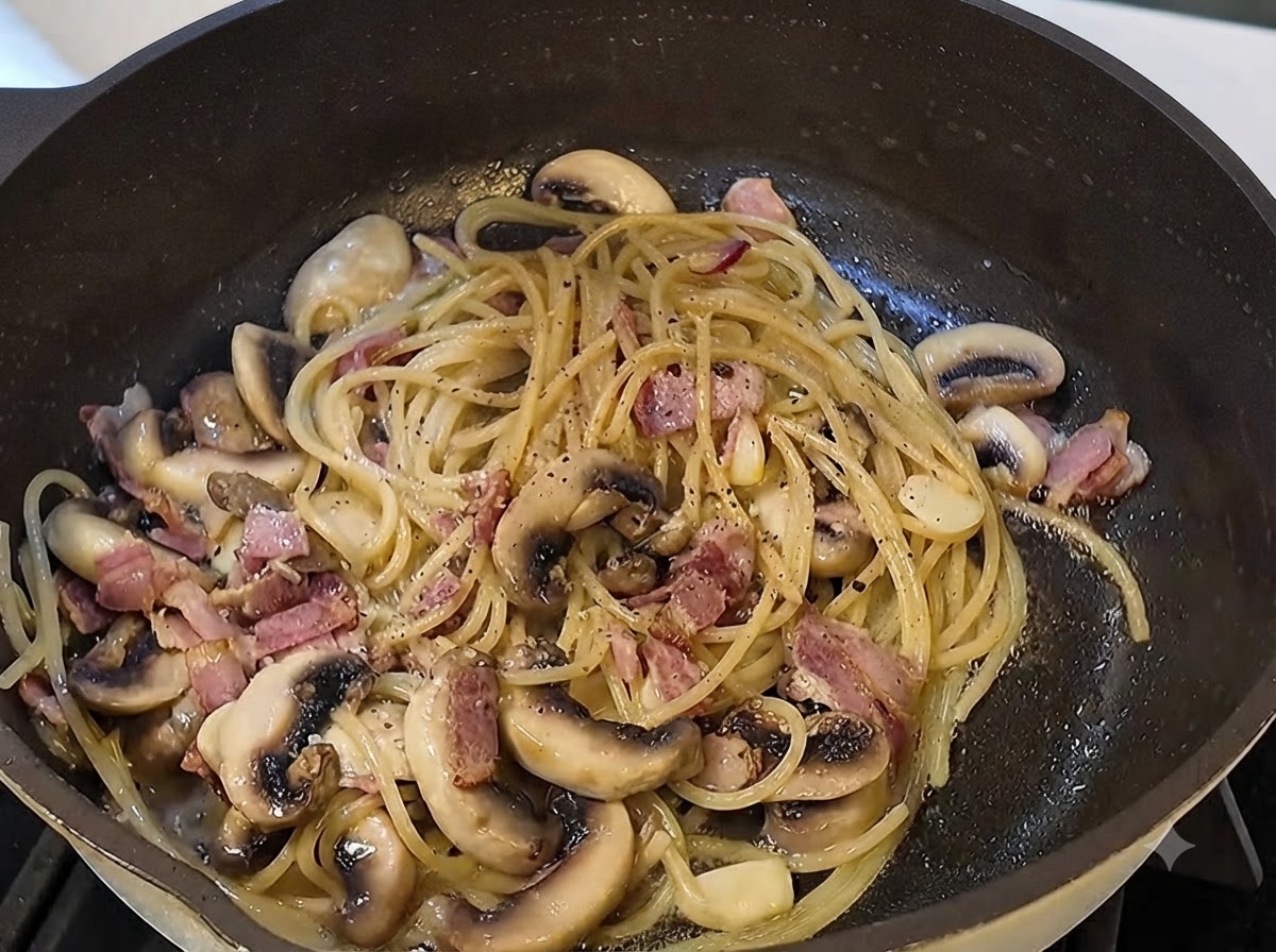 Salsa di tartufo nero e pepe nero macinato fresco che vengono incorporati nella padella della pasta.