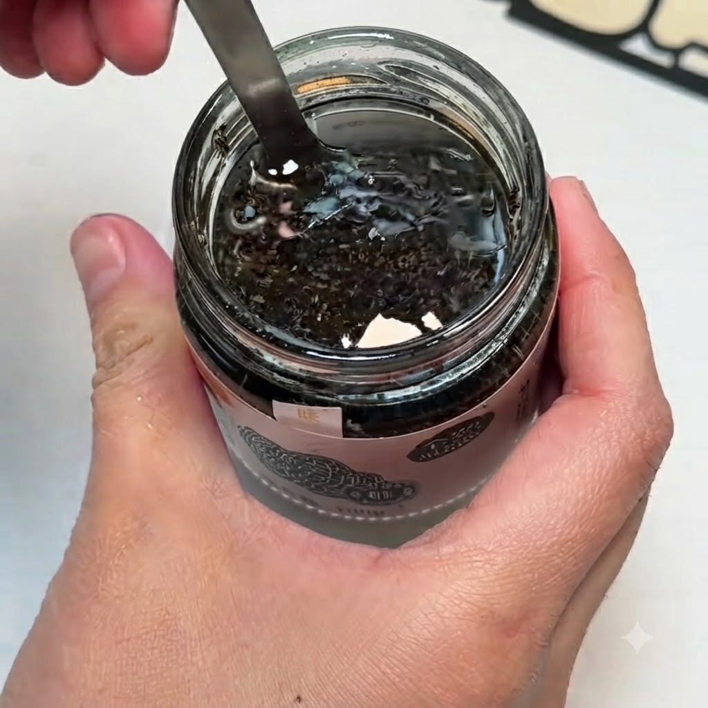 Una ciotolina contenente salsa al tartufo nero, tuorli duovo e sale mescolati con un cucchiaio.