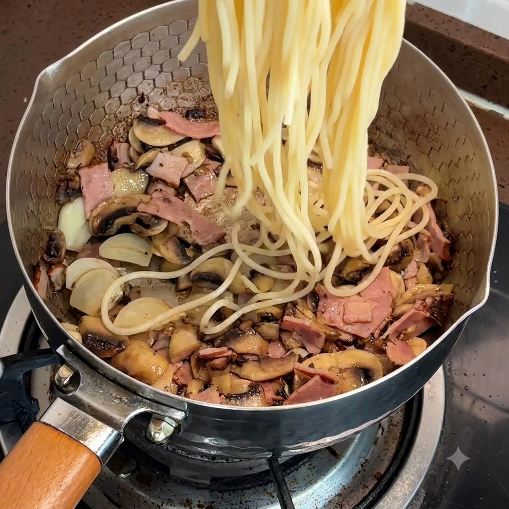 Spaghetti cotti aggiunti alla padella con pancetta e funghi.