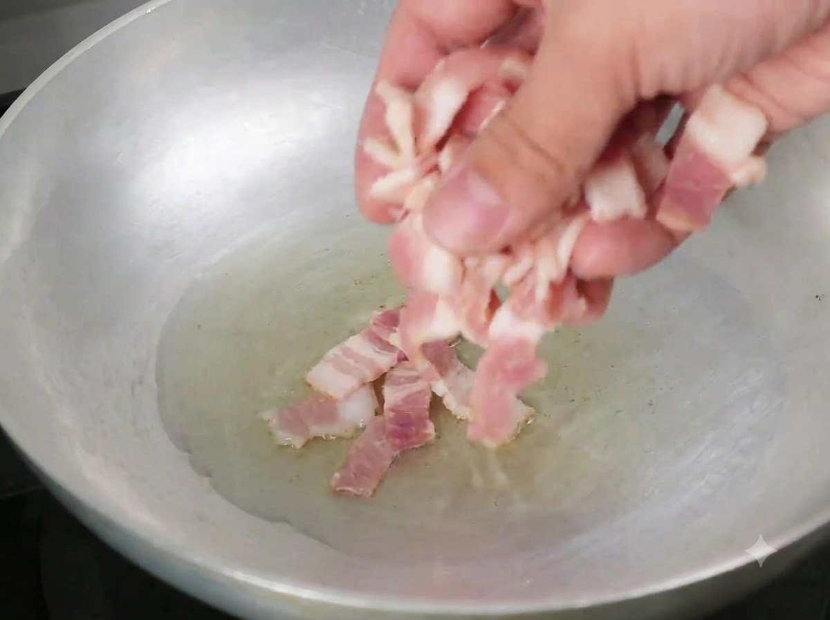 Pezzetti di pancetta aggiunti in una padella con olio doliva caldo.