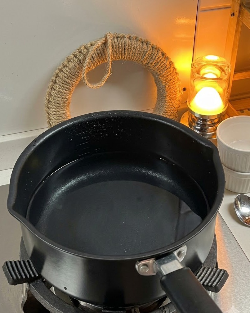 Pasta fusilli secca aggiunta a una pentola di acqua bollente sul fuoco.