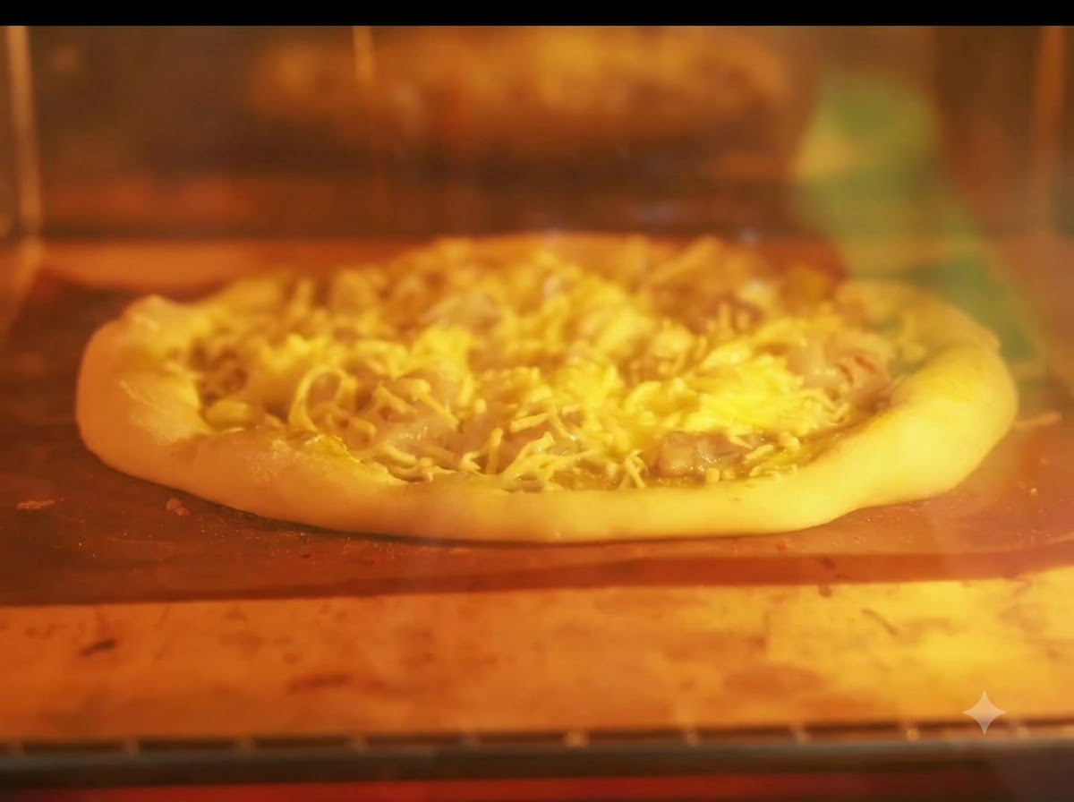 Una pizza in cottura su una teglia allinterno di un forno acceso con elementi riscaldanti incandescenti.