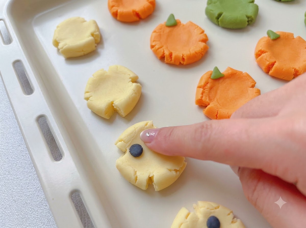 Piccoli pezzi di impasto colorato attaccati alle basi di biscotti appiattite per formare disegni spettrali.