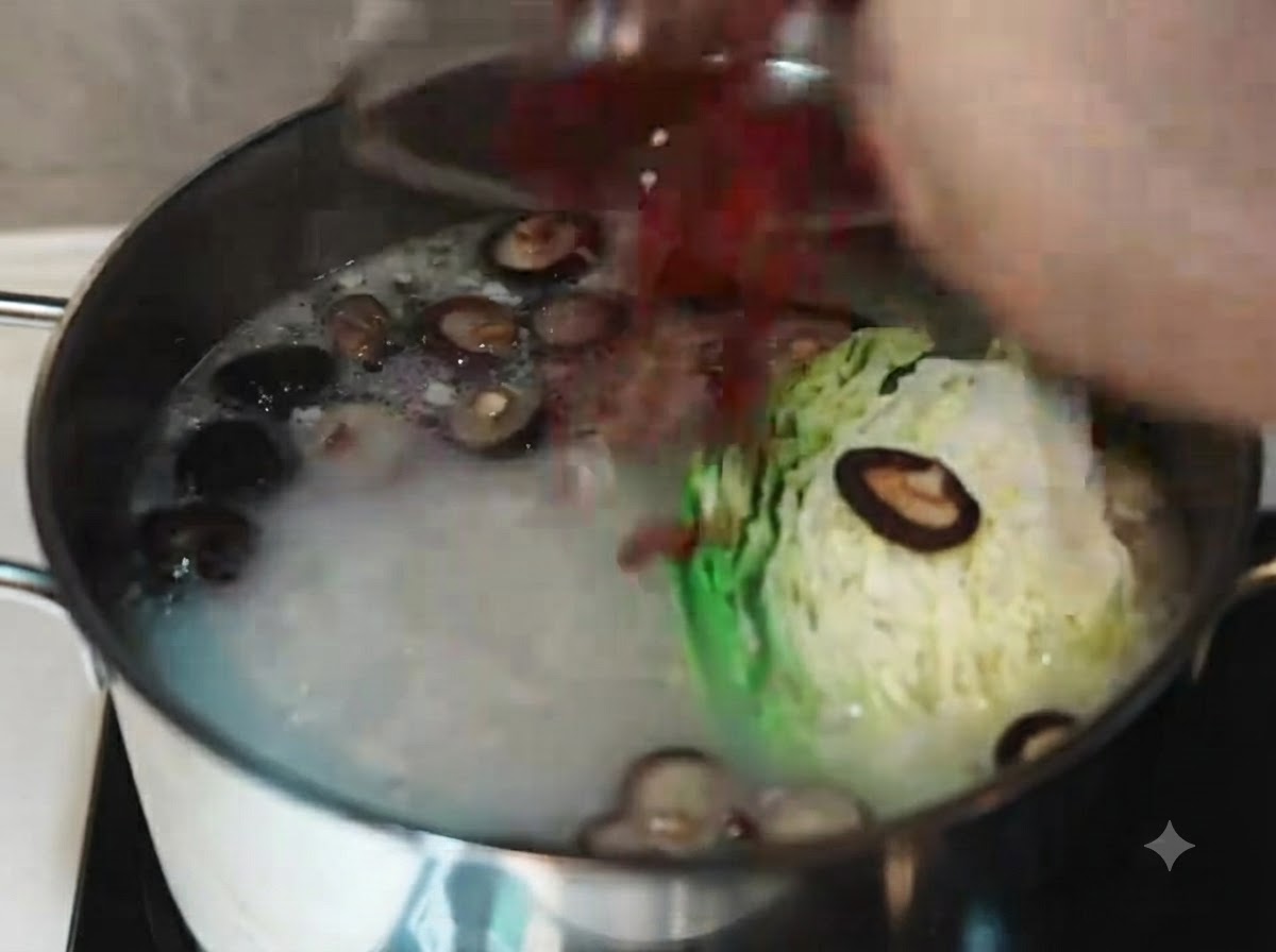 Mescolare il brodo di maiale bollente e opaco con un mestolo bianco dopo aver aggiunto cavolo, carote a fette, funghi shiitake e bacche di goji.