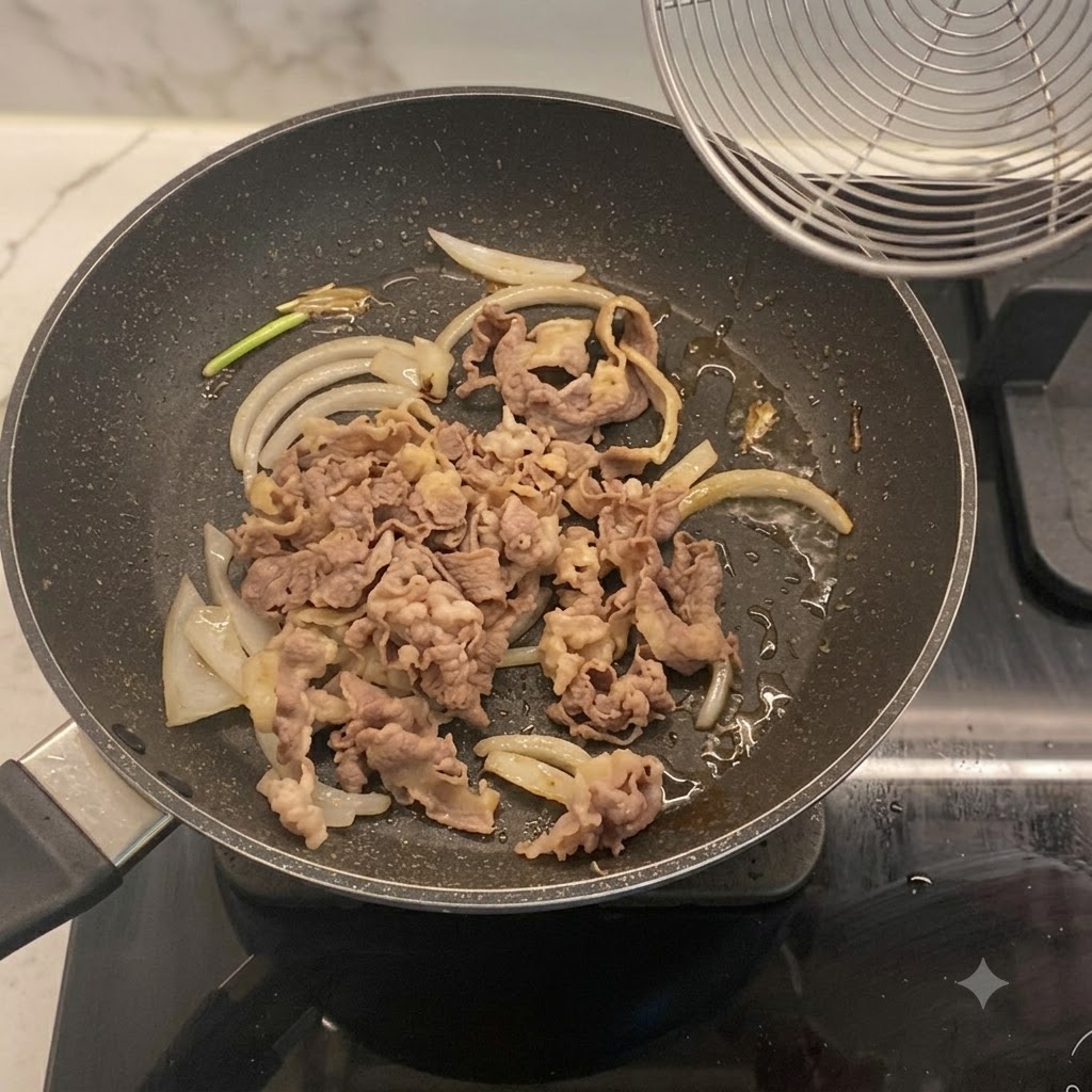 Fettine di manzo sbollentate mescolate alle cipolle in padella.