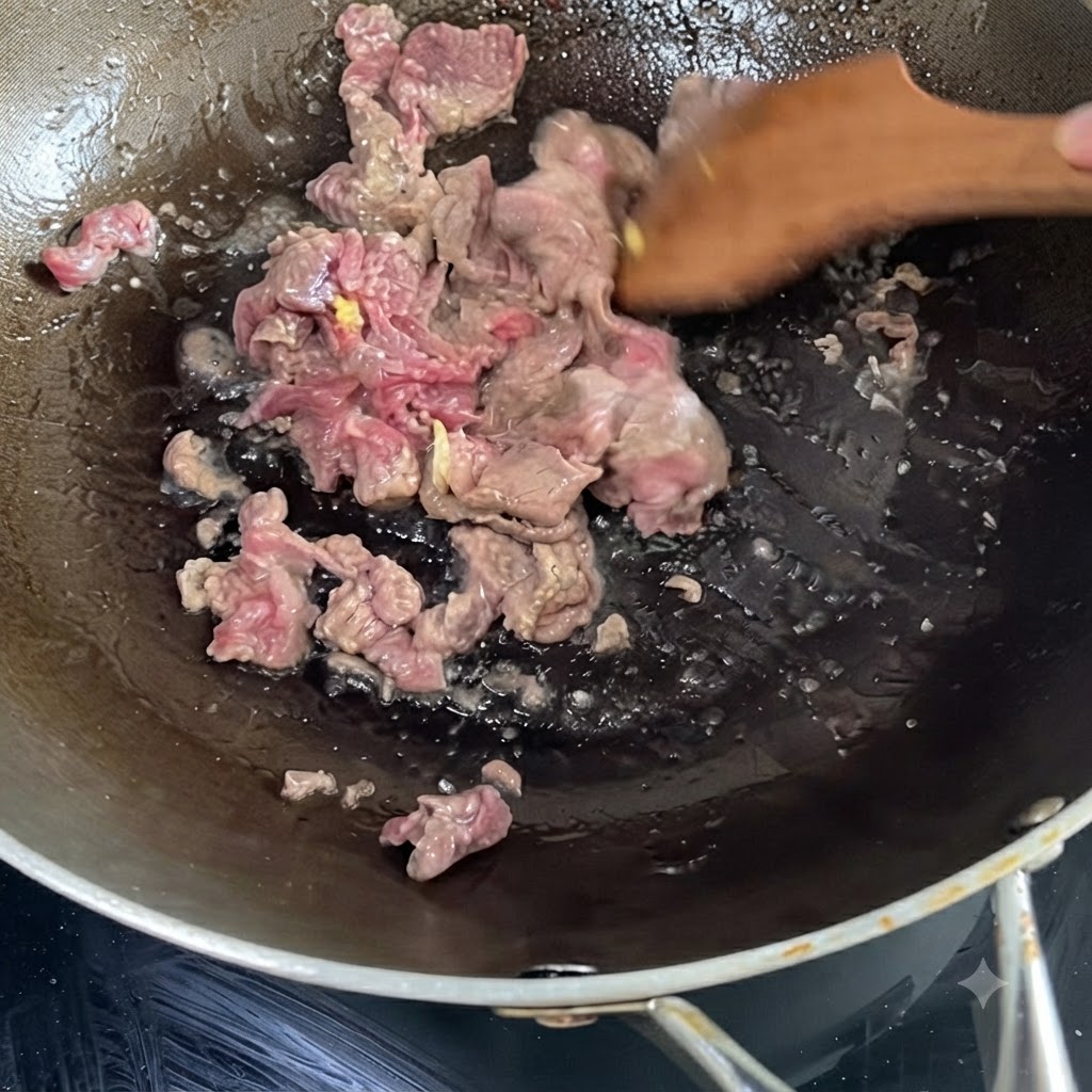 Manzo marinato che sfrigola e viene saltato in un wok caldo usando una spatola di legno.
