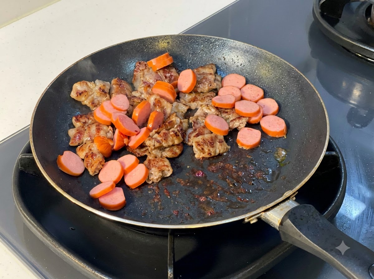 Salsicce affettate aggiunte nella padella contenente le fettine di manzo cotte.