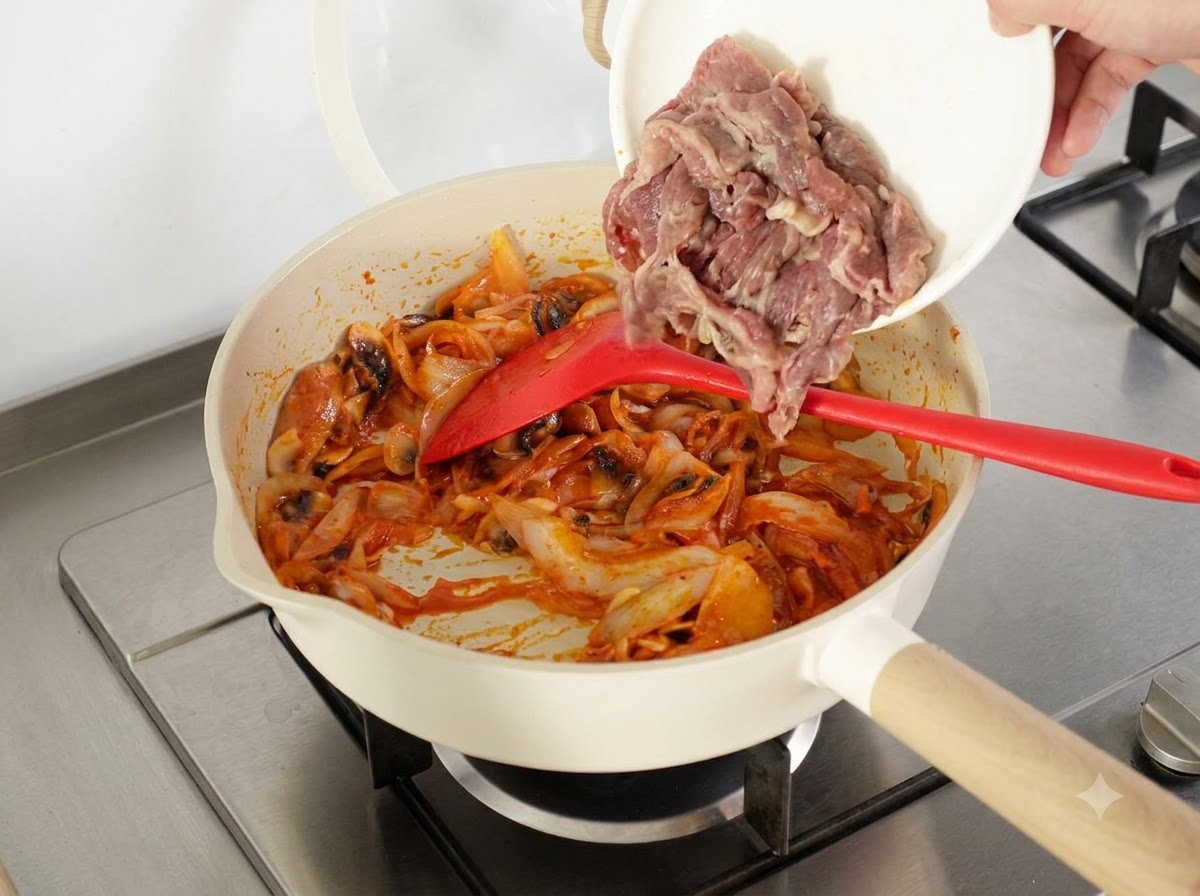 Fette di manzo sbollentate e una ciotola di riso cotto del giorno prima aggiunte nella padella.