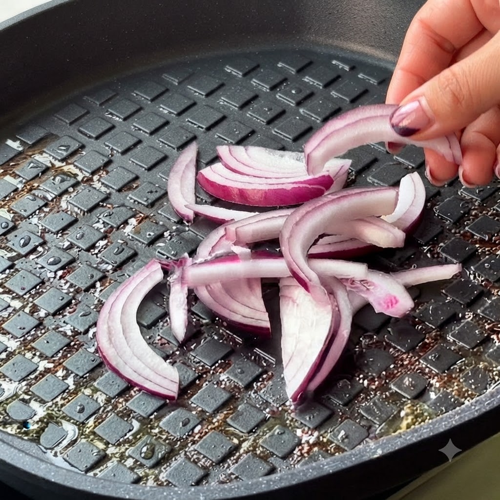 Cipolla rossa affettata e kimchi aggiunti nella padella.